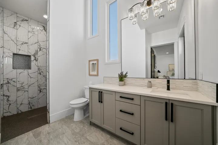 Dual sink vanity with light gray cabinetry and modern black hardware
