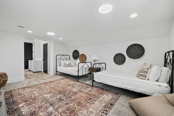 White walls with recessed lighting and a skylight