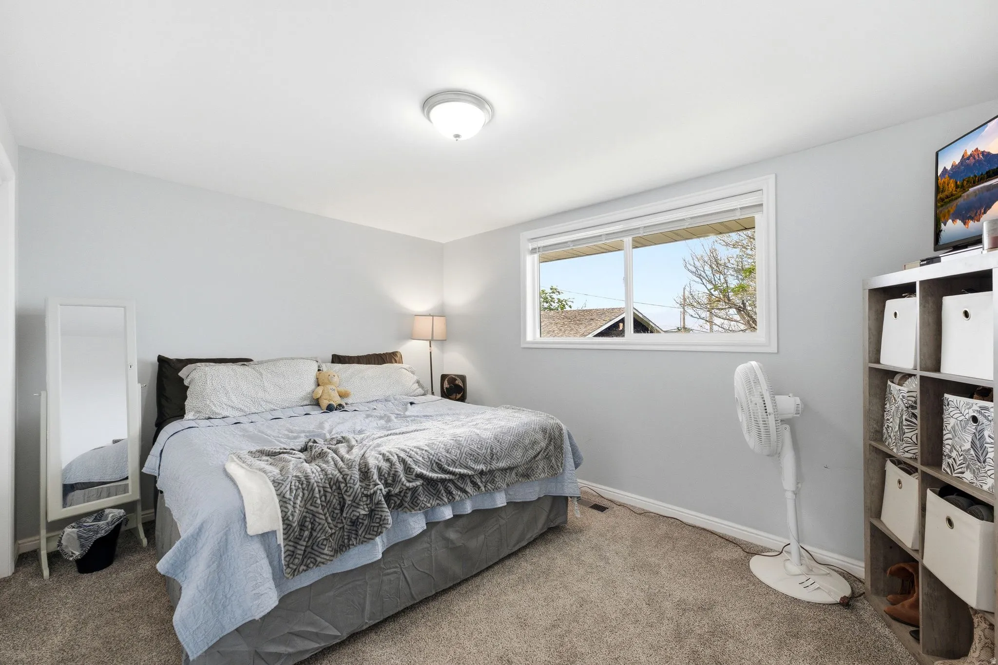Carpet flooring, recessed ceiling light, window with white trim, and a built-in shelving unit