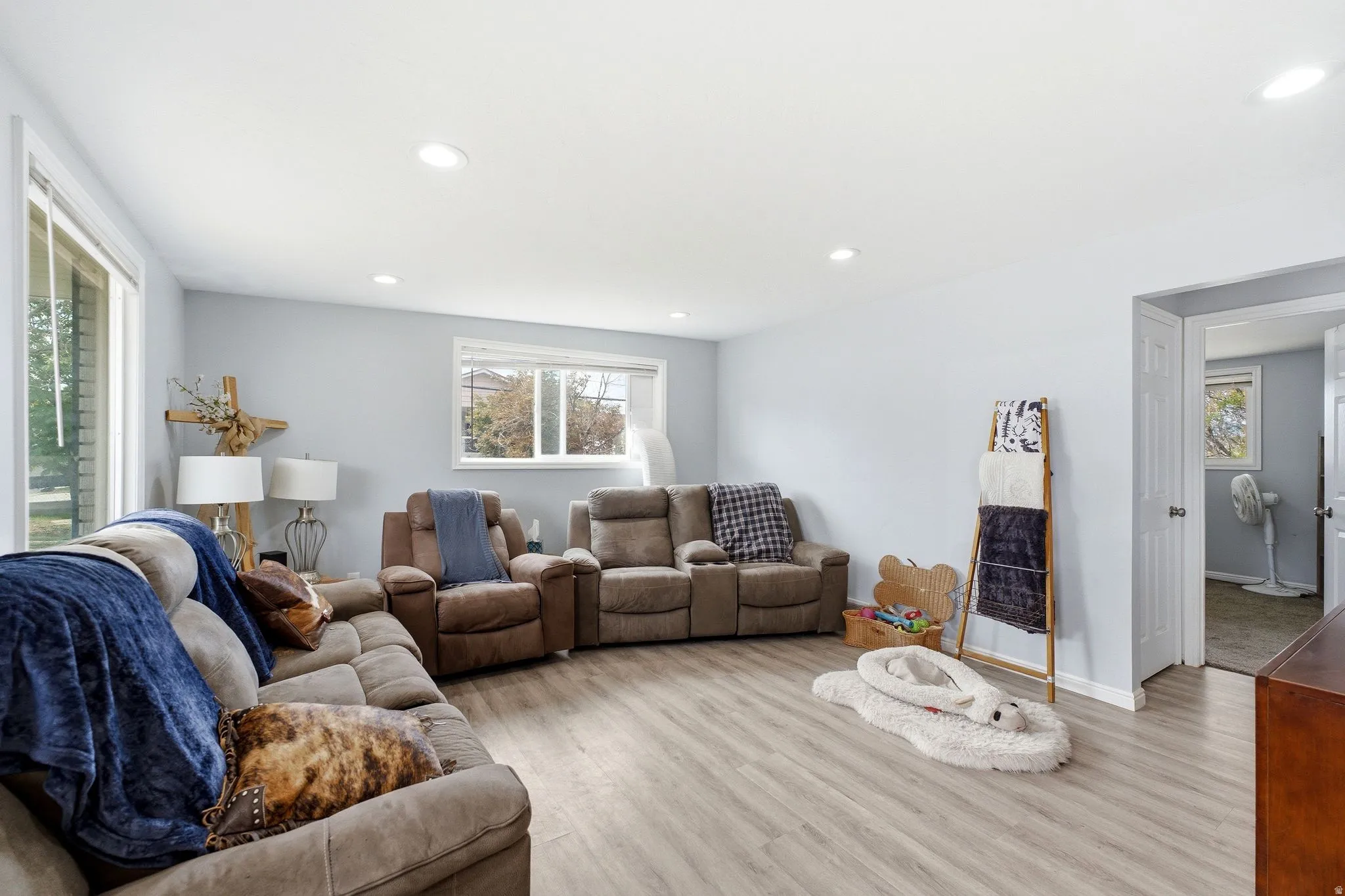 Spacious living area featuring wood-finish flooring, recessed lighting, and multiple windows