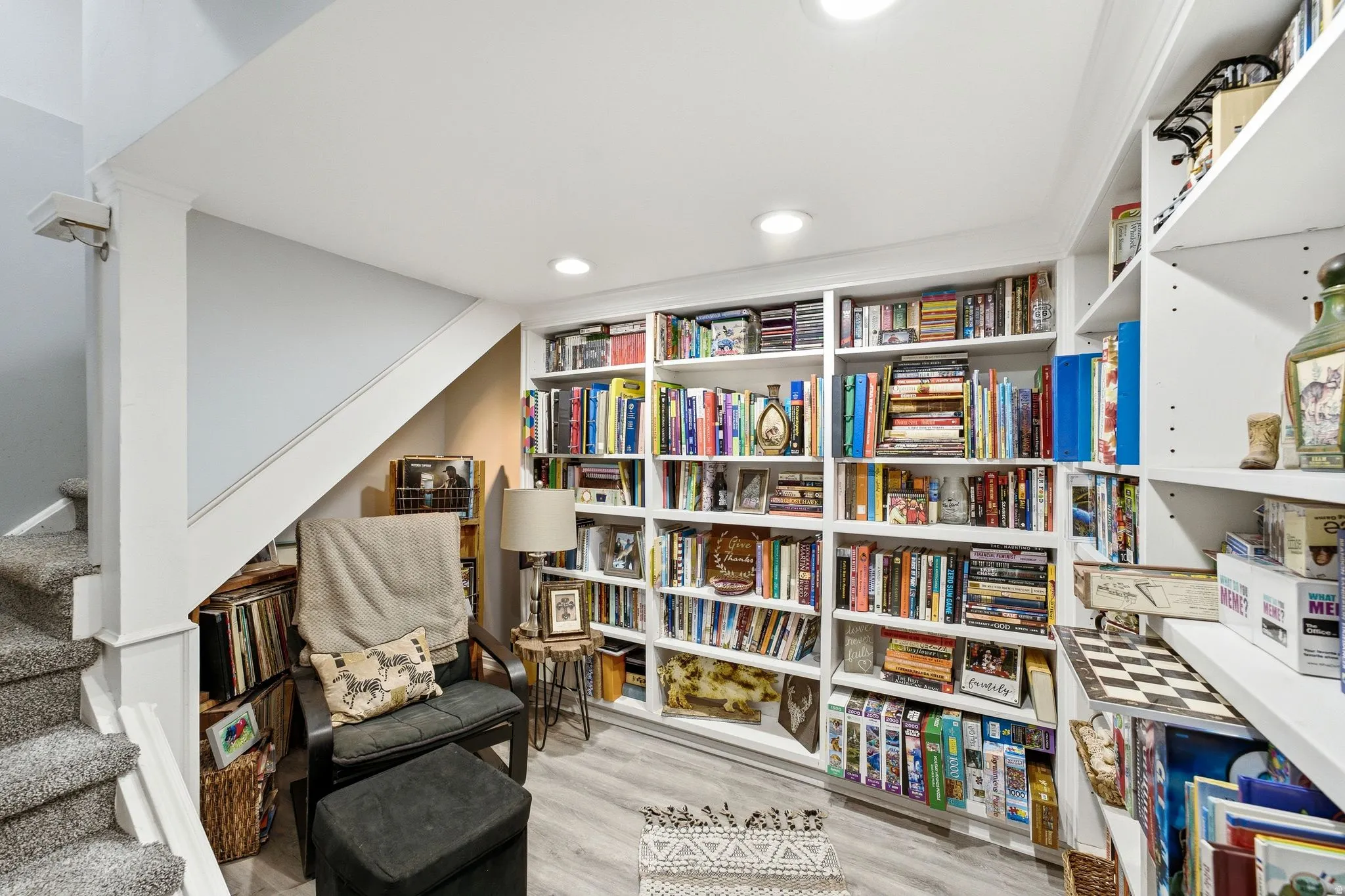 Built-in shelving, recessed lighting, wood-finish flooring, and a carpeted staircase