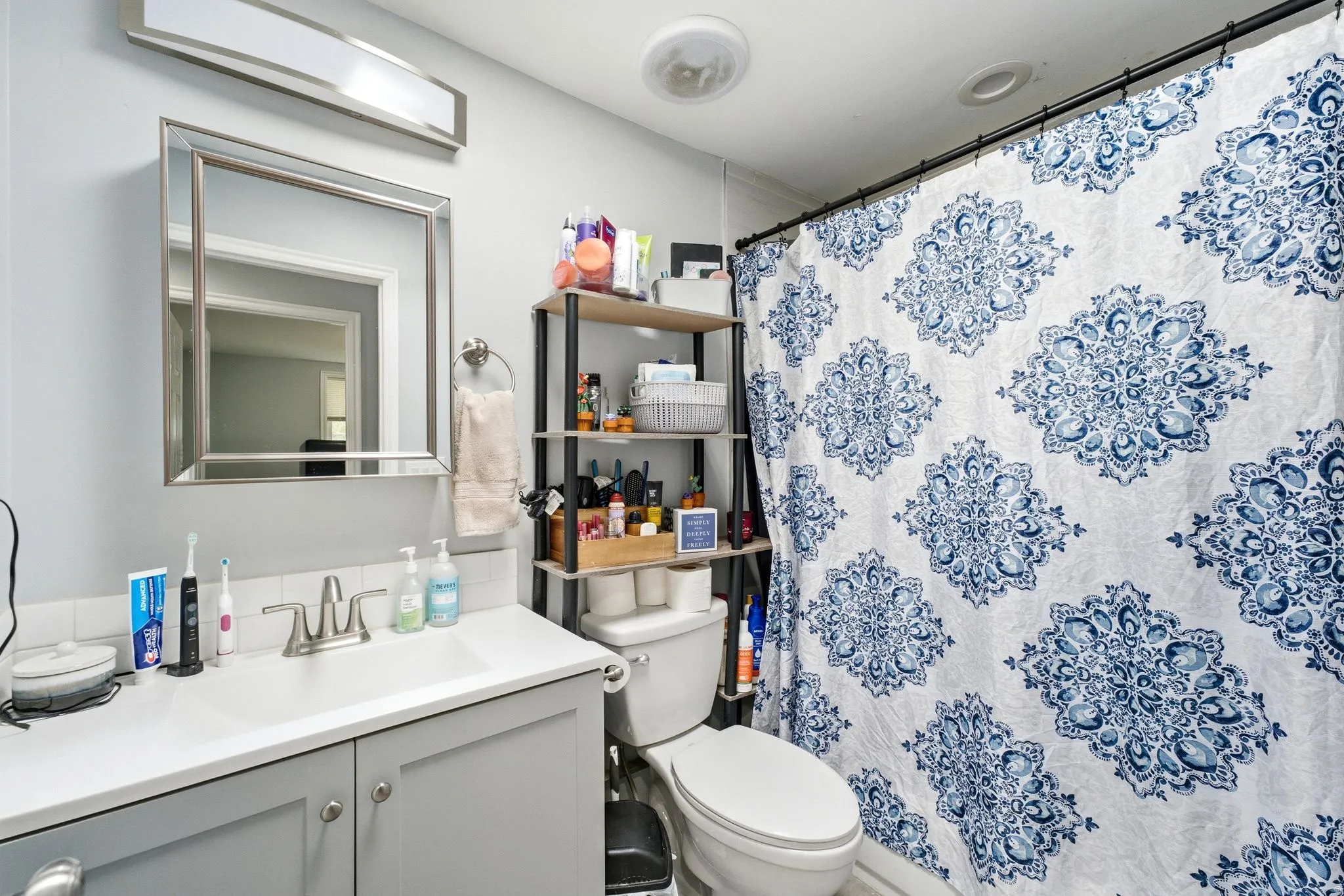 Modern vanity with integrated sink, brushed nickel faucet, and a framed mirror