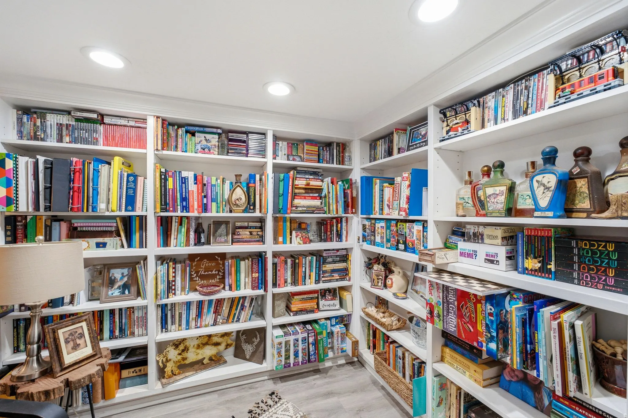 Recessed lighting illuminates extensive built-in shelving, complemented by wood-finish flooring