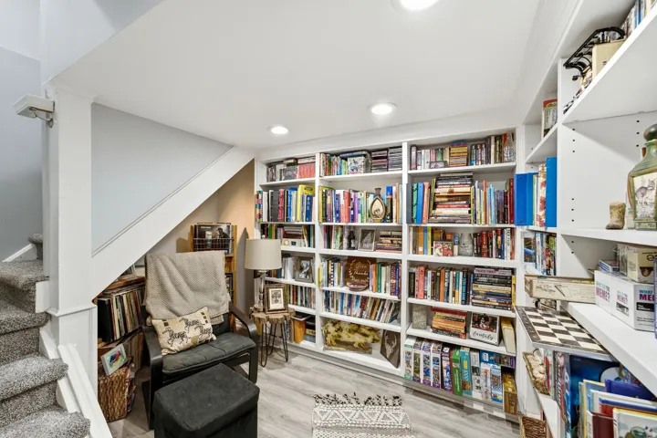 Built-in shelving, recessed lighting, wood-finish flooring, and a carpeted staircase