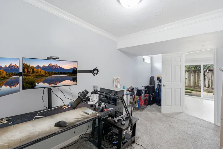 Carpeted room with a five-panel interior door, crown molding, and a built-in light fixture