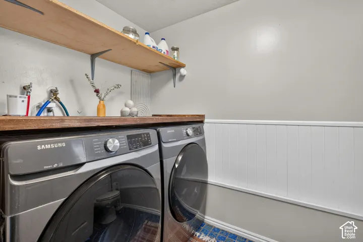 White wainscoting with a pale gray wall above, complemented by a wood-finish countertop and open shelving