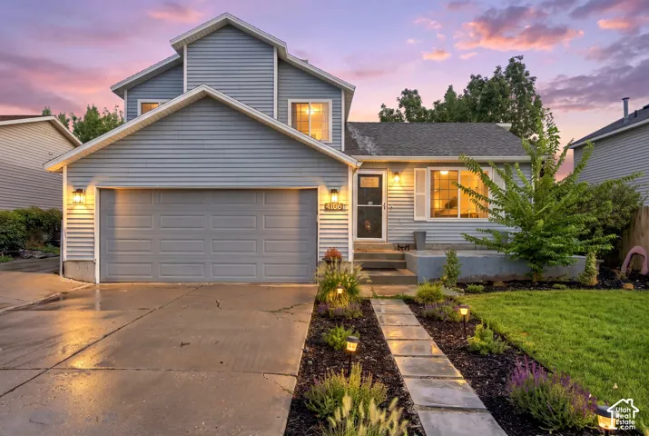 Two-story home with light blue siding, a multi-pane window, and a gray panel garage door