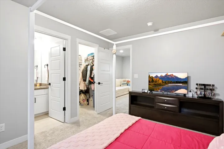 Plush carpeting throughout, white paneled doors with matte black hardware, and a built-in media console