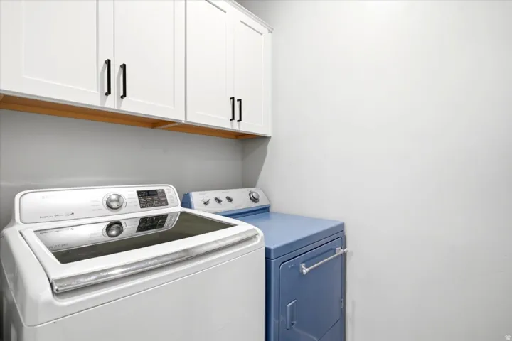 White shaker-style cabinetry with black hardware and a wood-finish under-cabinet accent