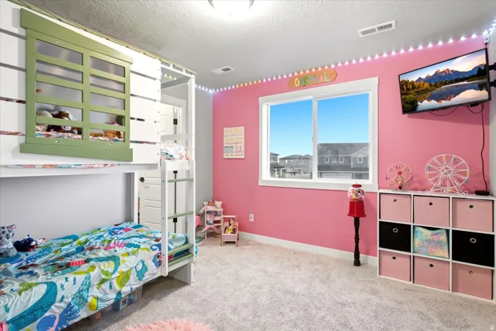 Built-in bunk bed structure with an integrated ladder, expansive window, wall-mounted television, and cube storage unit