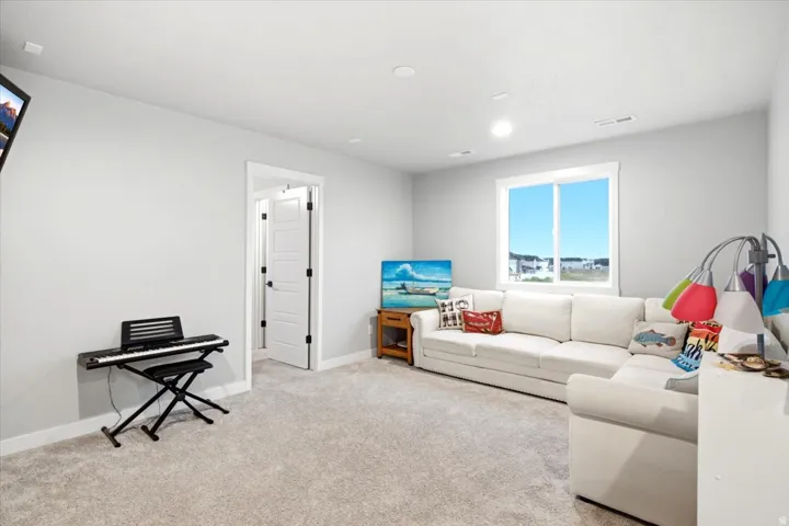 Recessed lighting, light gray wall color, white trim, and carpeted flooring