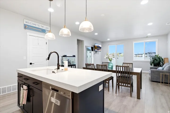 Kitchen island with an undermount sink, a matte black faucet, and a stainless steel dishwasher