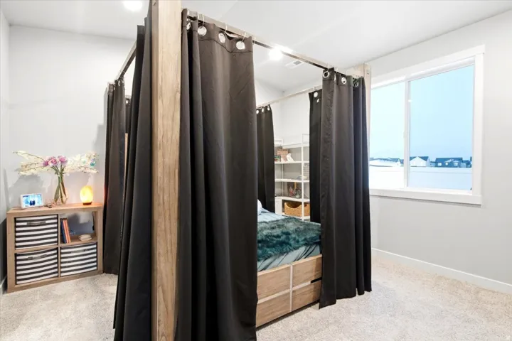 Carpeted room with a large window and light gray walls