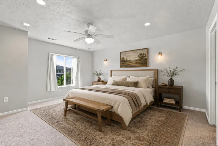 Recessed ceiling lighting, ceiling fan, natural light window, wall sconces, and neutral wall tones