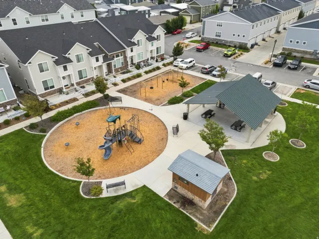 Recreational park area featuring a playground, covered pavilion with picnic tables, and a dedicated restroom facility