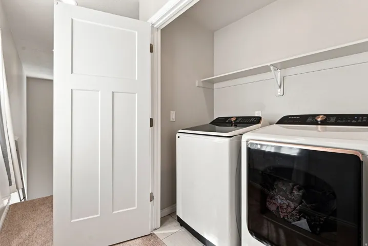 Dedicated laundry area featuring a white panel door, light gray walls, and a convenient wall-mounted shelf