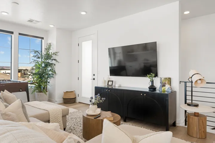 Light wood-finish flooring, recessed lighting, and large windows with dark frames