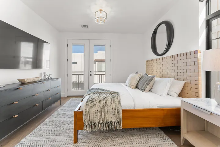 Wood-finish flooring throughout, featuring a double French door balcony access