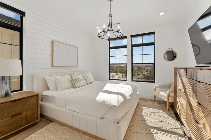 White shiplap accent wall, black-framed multi-pane windows, recessed lighting, and a metal chandelier