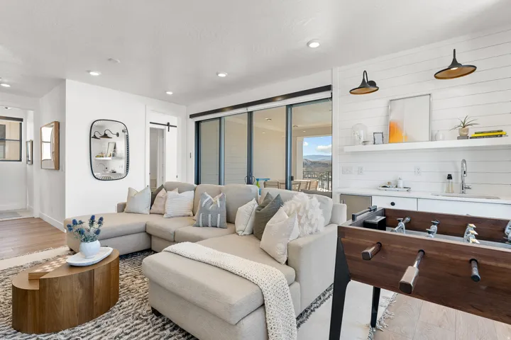 Recessed lighting, wood-finish flooring, and a wet bar with a built-in beverage refrigerator