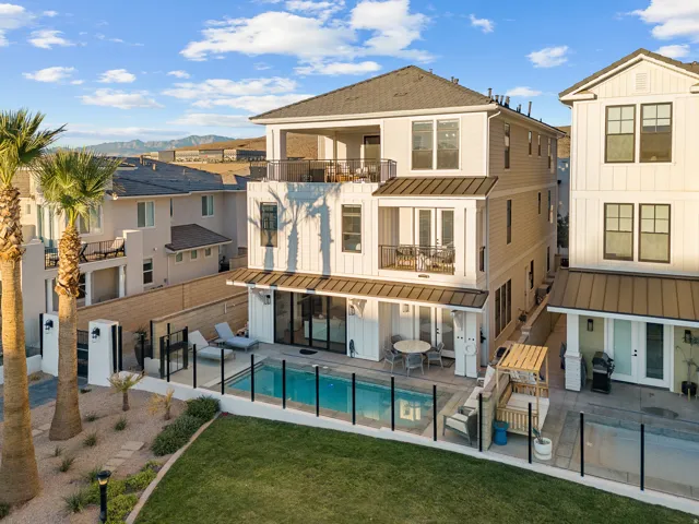 Multi-story residence featuring multiple balconies, board and batten siding, and a private pool with a surrounding patio