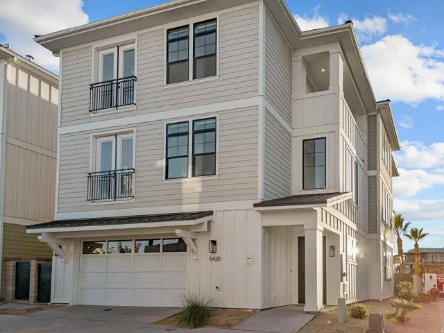 Modern exterior featuring mixed siding, a two-car garage, and multiple balcony elements