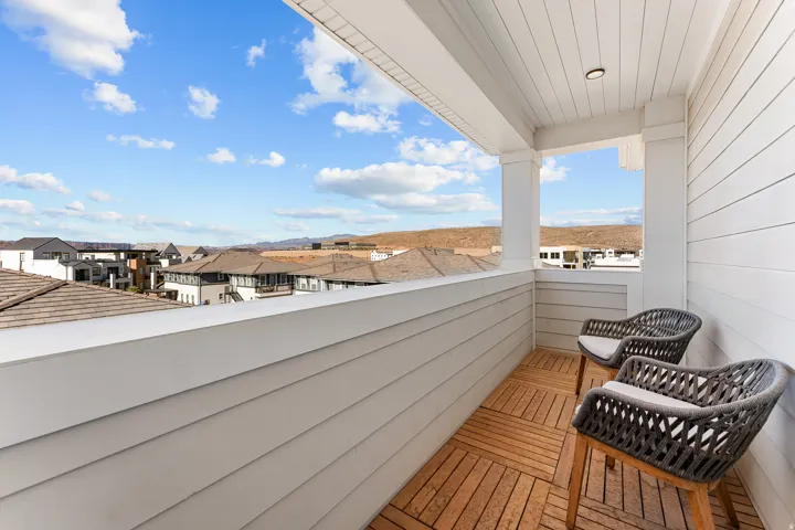 Balcony with wood-finish flooring, white siding, and recessed lighting