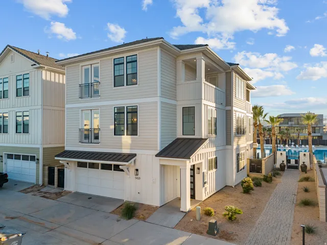 Three-story exterior with horizontal and vertical siding, multiple balconies, a covered entry, and a two-car garage