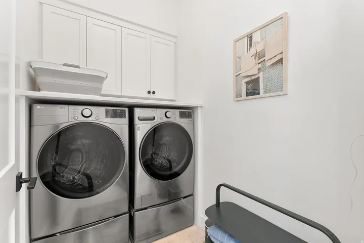 Built-in white cabinetry, integrated stainless steel appliances, and a functional upper shelf