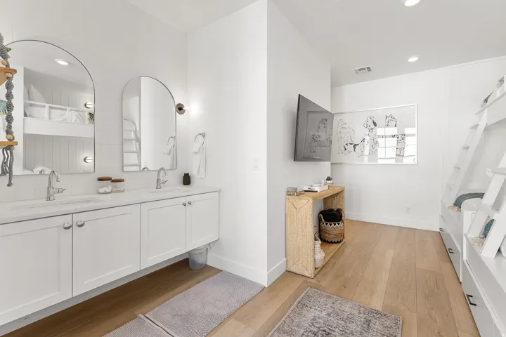 Dual arched mirrors above a double vanity with integrated sinks
