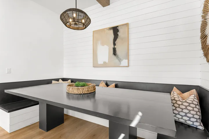 Built-in dining nook with integrated bench seating, shiplap wall treatment, and wood-finish flooring