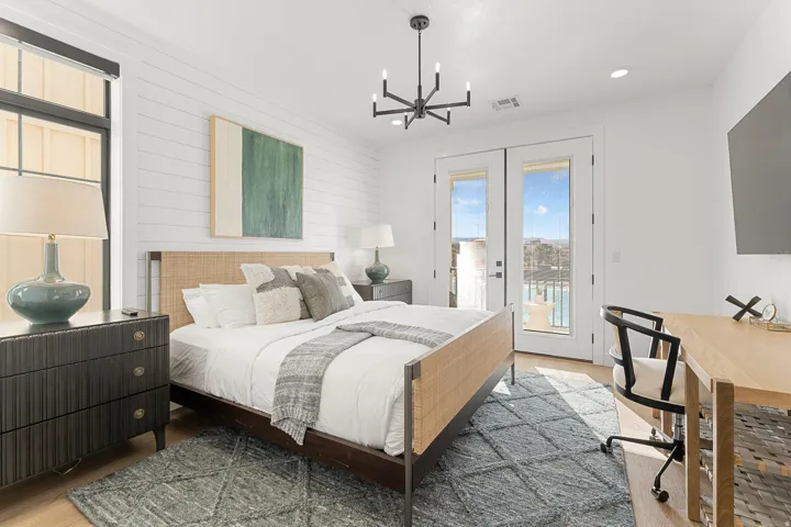 Shiplap accent wall, light wood-finish flooring, black-framed windows, double glass doors, and a modern chandelier