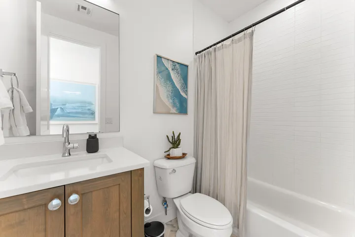 Bathroom featuring a wood-finish vanity with an integrated sink, polished chrome faucet, and a large wall mirror
