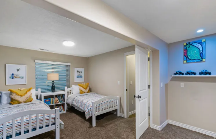 Recessed lighting, wall-to-wall carpeting, window with horizontal blinds, built-in wall shelf
