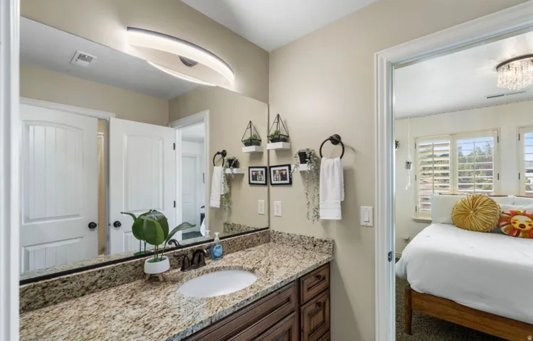 Vanity featuring a stone-finish countertop, undermount sink, and dark wood-finish cabinetry