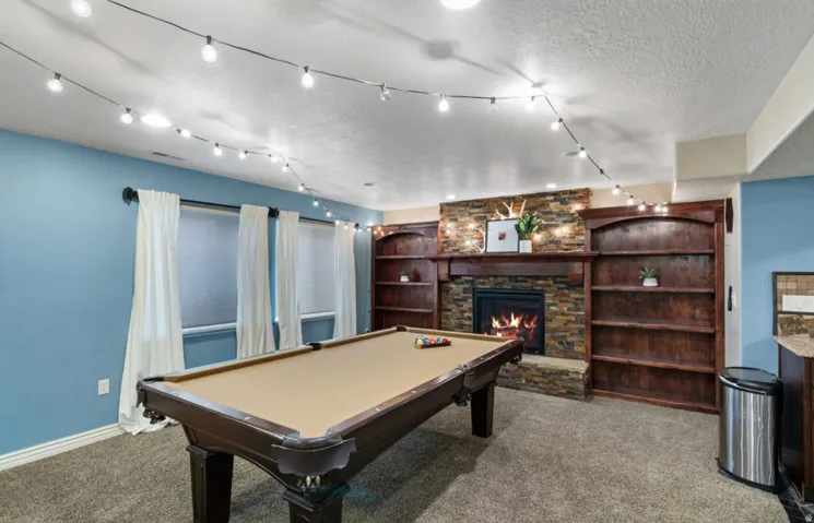 Built-in shelving flanking a stone-faced fireplace with a wood mantel