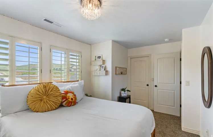 Plantation shutters, crystal chandelier, two panel interior doors, beadboard interior door, wall-mounted oval mirror