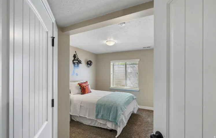 Room featuring a ceiling-mounted light fixture, window with blinds, and neutral-toned walls