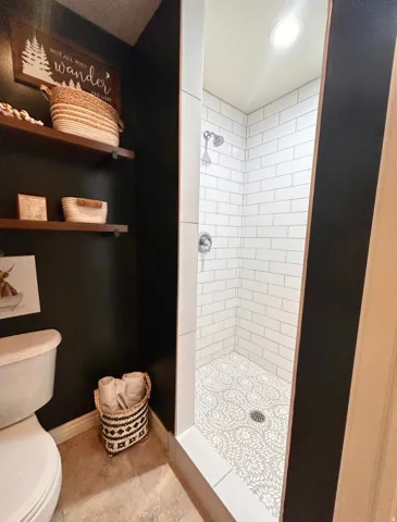 Walk-in shower with subway tile surround, patterned floor tile, recessed lighting, and chrome shower fixtures