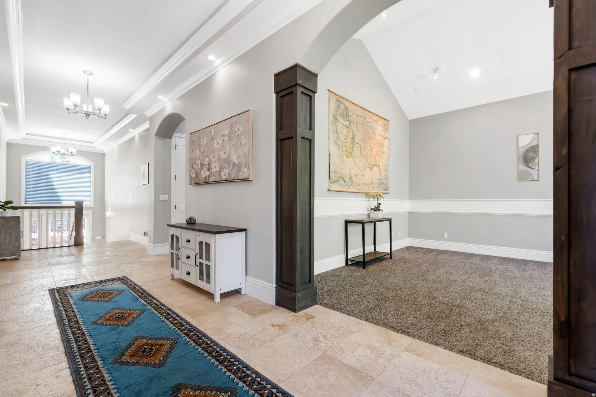 Tiled entryway with tray ceiling and recessed lighting, leading to an arched doorway