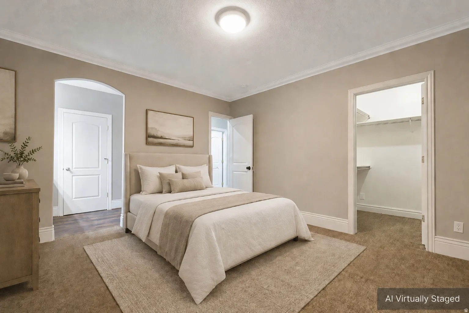 Plush carpet flooring, crown molding, arched doorway, and a walk-in closet