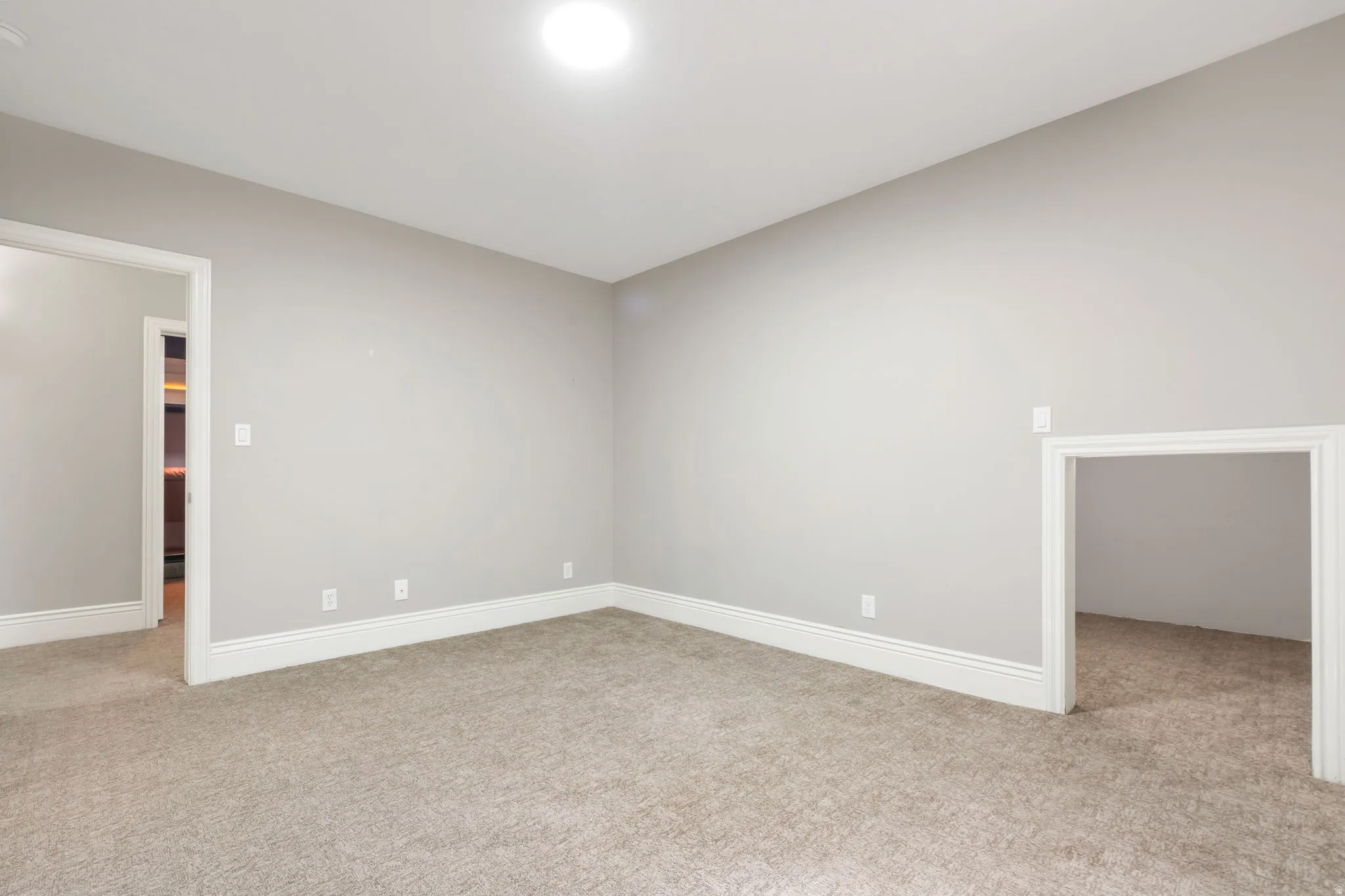 Recessed ceiling light, neutral wall paint, carpeted flooring, white trim, and a small alcove