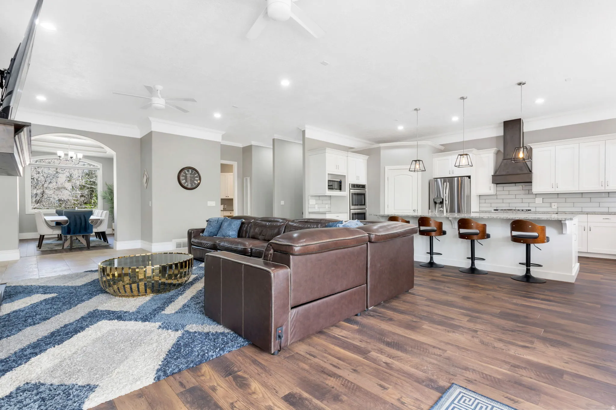 Open-concept living area with wood-finish flooring, recessed lighting, and a kitchen island with pendant lighting