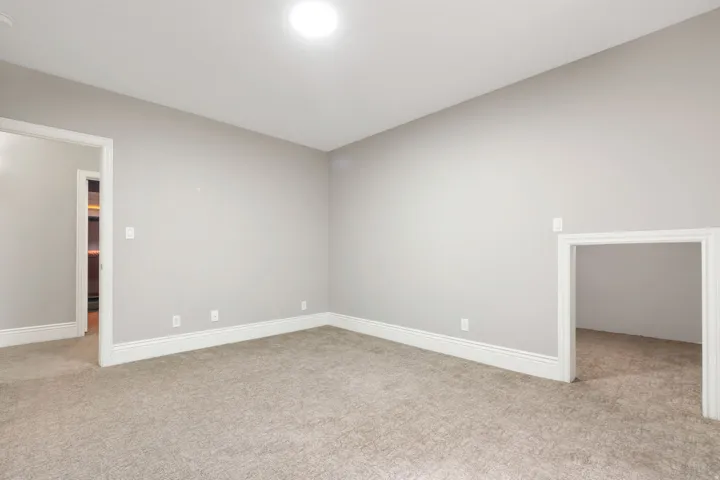 Recessed ceiling light, neutral wall paint, carpeted flooring, white trim, and a small alcove