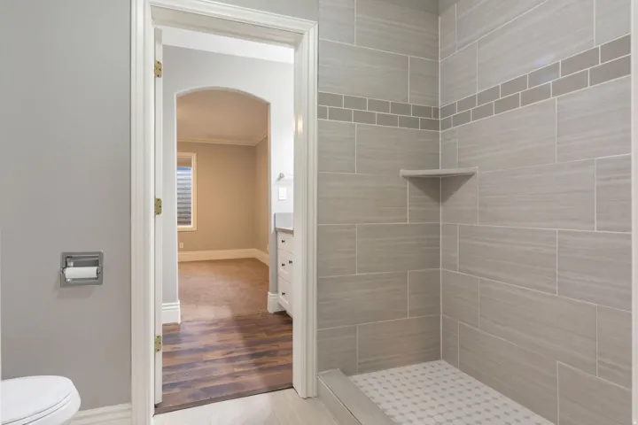 Tiled shower with a decorative accent band and built-in corner shelf