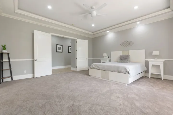 Recessed lighting, ceiling fan, crown molding, double doors, and carpet flooring