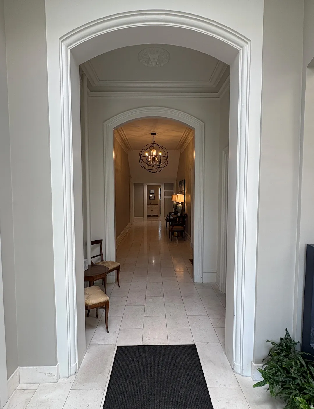 Archway entry with detailed millwork, decorative ceiling medallion, tile flooring, and recessed lighting