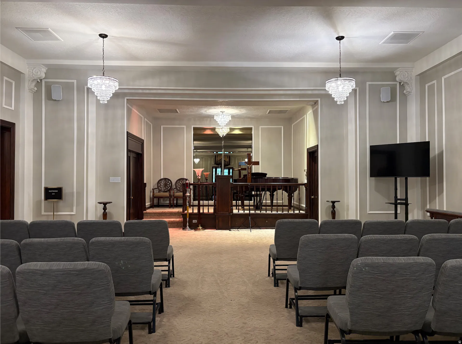 Recessed lighting, decorative crown molding, and two tiered crystal chandeliers illuminate the interior