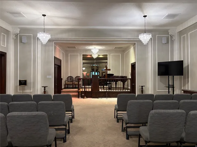 Recessed lighting, decorative crown molding, and two tiered crystal chandeliers illuminate the interior