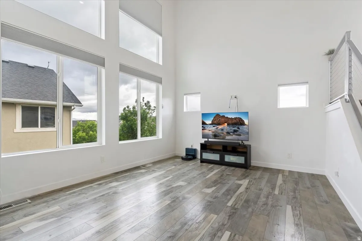 Expansive living area featuring soaring ceilings and wood-finish flooring